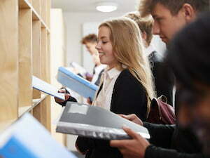Teenage Students Putting Away Books After Class